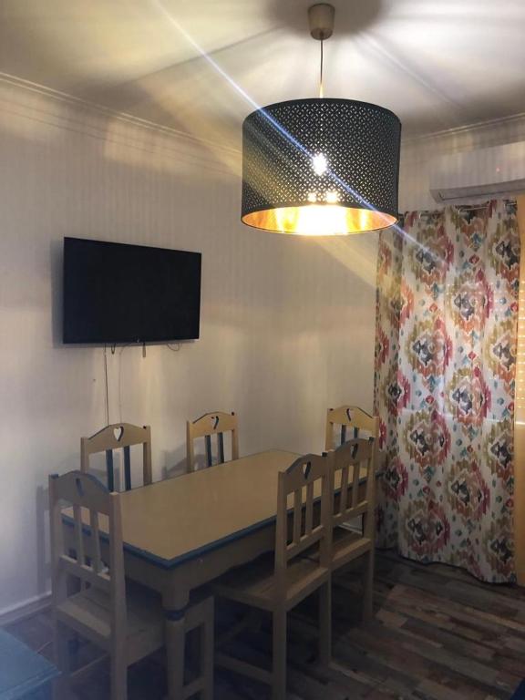 a dining room with a table and chairs and a television at Alojamento Mercado Sul in Lisbon