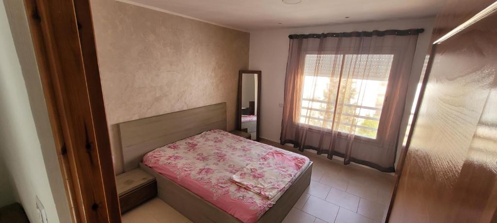 ein kleines Schlafzimmer mit einem Bett und einem Fenster in der Unterkunft Apparts MT in Sousse