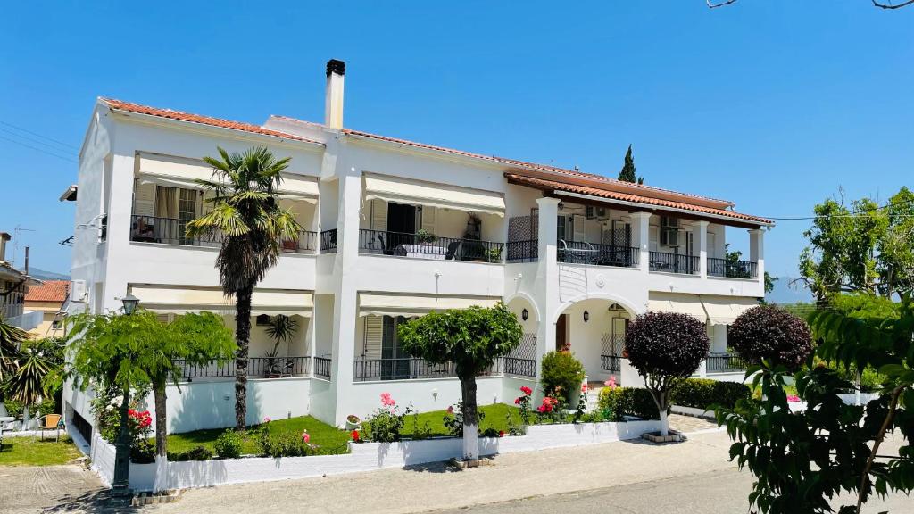 厄蒙斯的住宿－Villa Deza，一座白色的建筑,前面有棕榈树