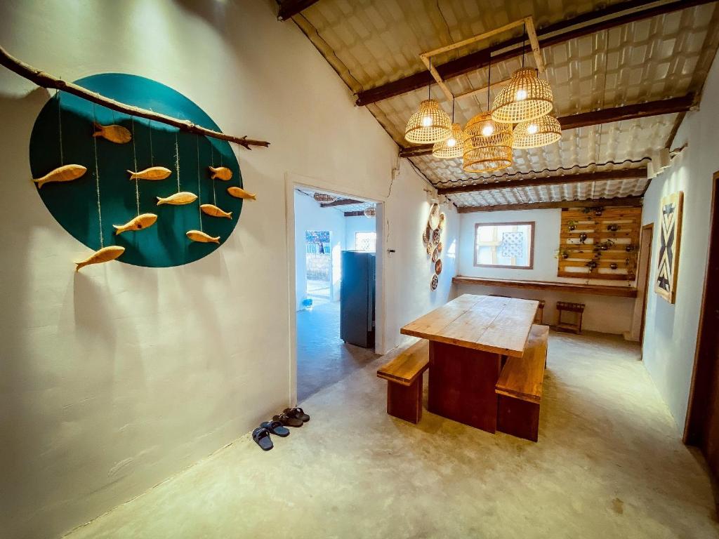 a room with a table and some fish on the wall at Bluesea Homestay in Phu Yen