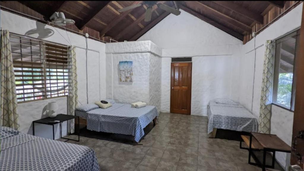 a bedroom with two beds and a table and a window at Ocean View in Puntarenas