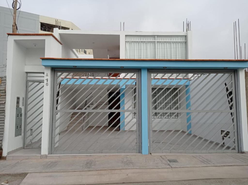 a metal garage door with a blue roof at DEPARTAMENTO AMOBLADO in Tacna