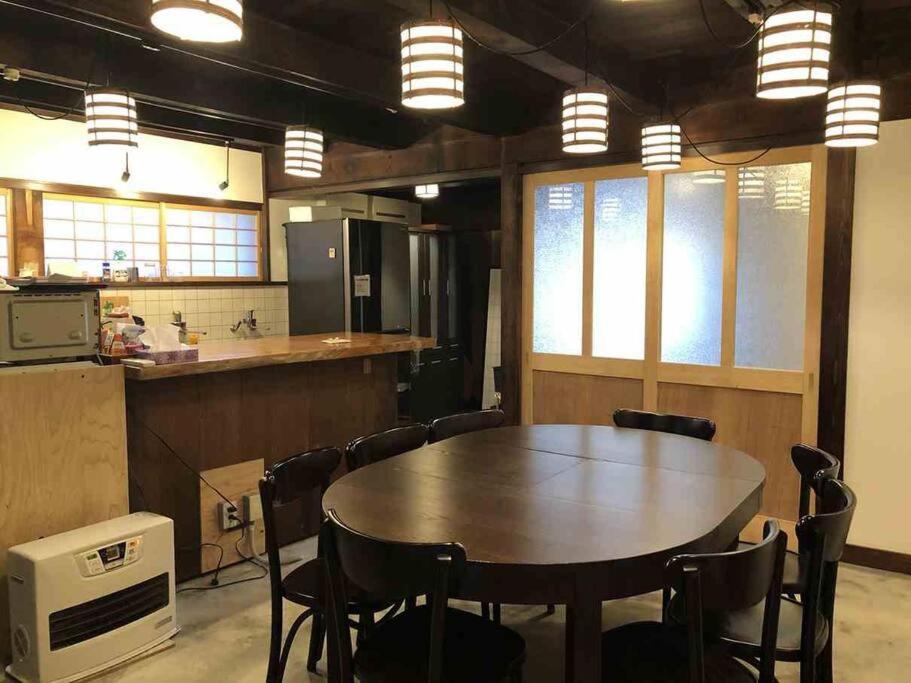 a kitchen with a table and chairs in a room at 越中城端　荒町庵 in Nanto