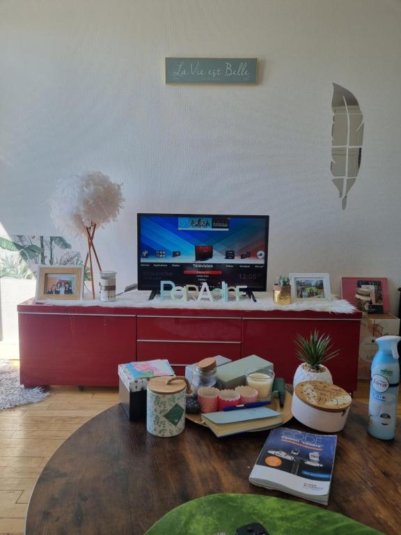 een woonkamer met een tv en een tafel met eten bij Appartement cosy en plein centre in Guidel