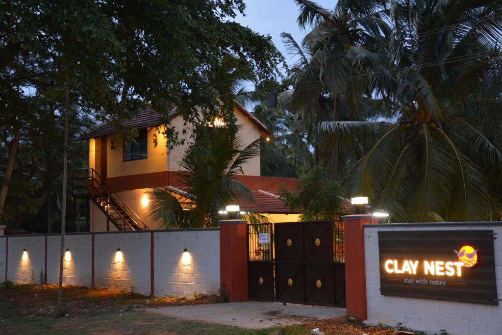 een huis met Alex Nest bord ervoor bij ClayNest Resorts in Kuttālam