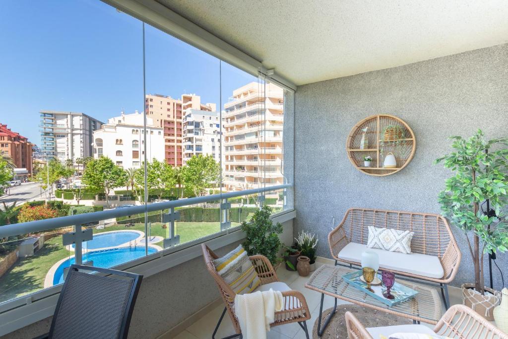 a balcony with a couch and a table and chairs at Apolo XVIII - Costa CarpeDiem in Calpe