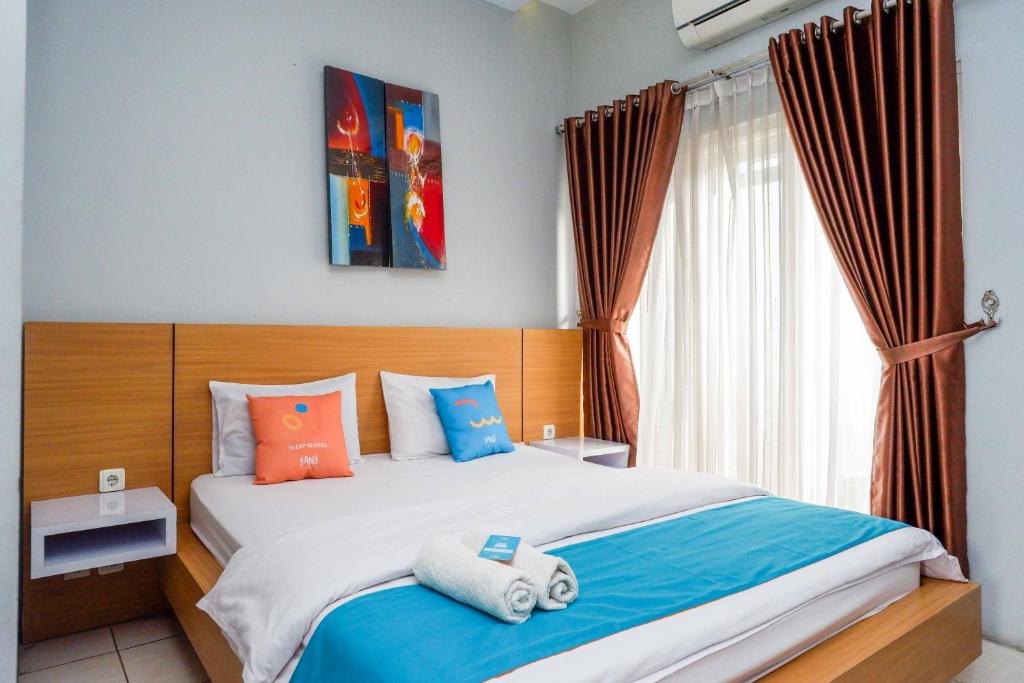 Postel nebo postele na pokoji v ubytování Sans Hotel Absari Yogyakarta