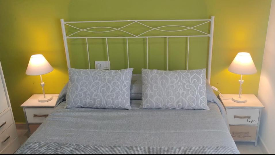 ein Schlafzimmer mit einem Bett mit zwei Lampen an Tischen in der Unterkunft Apartamento Bienvenida in Bienvenida