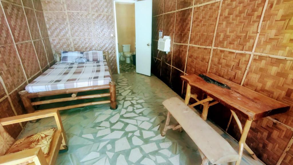 a room with two beds and a bench in it at SunnySide bed & bar in Siquijor