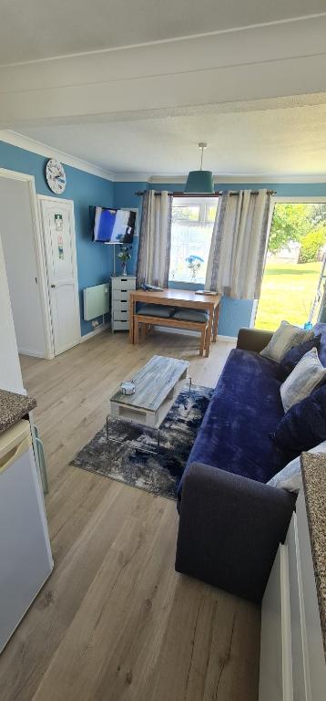 uma sala de estar com um sofá e uma mesa em Isle of Wight Chalet em Sandown