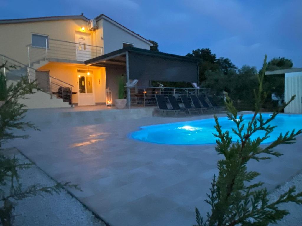 una piscina frente a una casa por la noche en Aleya FERIENHAUS mit Pool, en Medulin