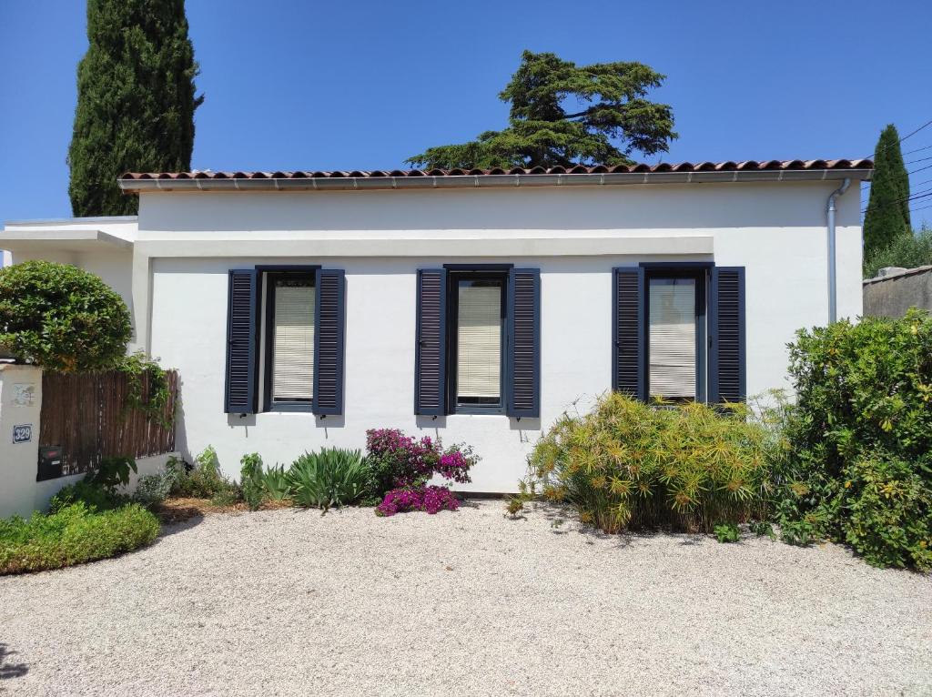 une maison blanche avec volets noirs dans l'établissement Maison avec jardin à 5 minutes à pied des plages, à La Ciotat