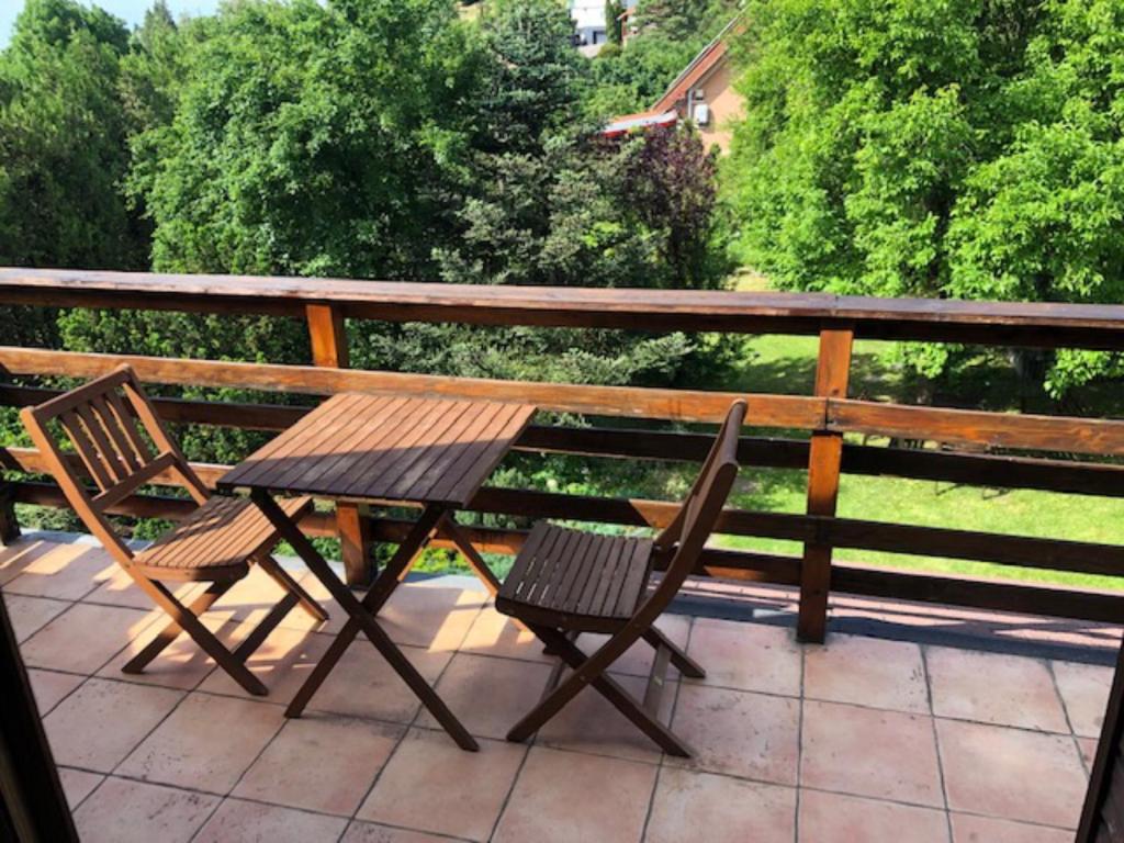 een houten tafel en 2 stoelen op een patio bij Tulipán ház in Szentendre