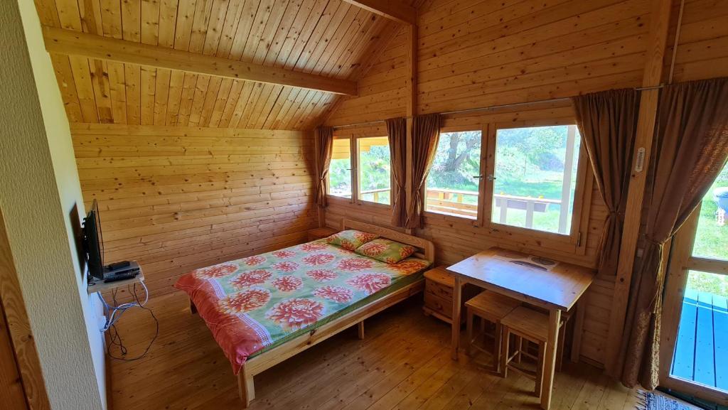 una habitación con una cama y una mesa en una cabaña en Jaunveiti, en Bernāti