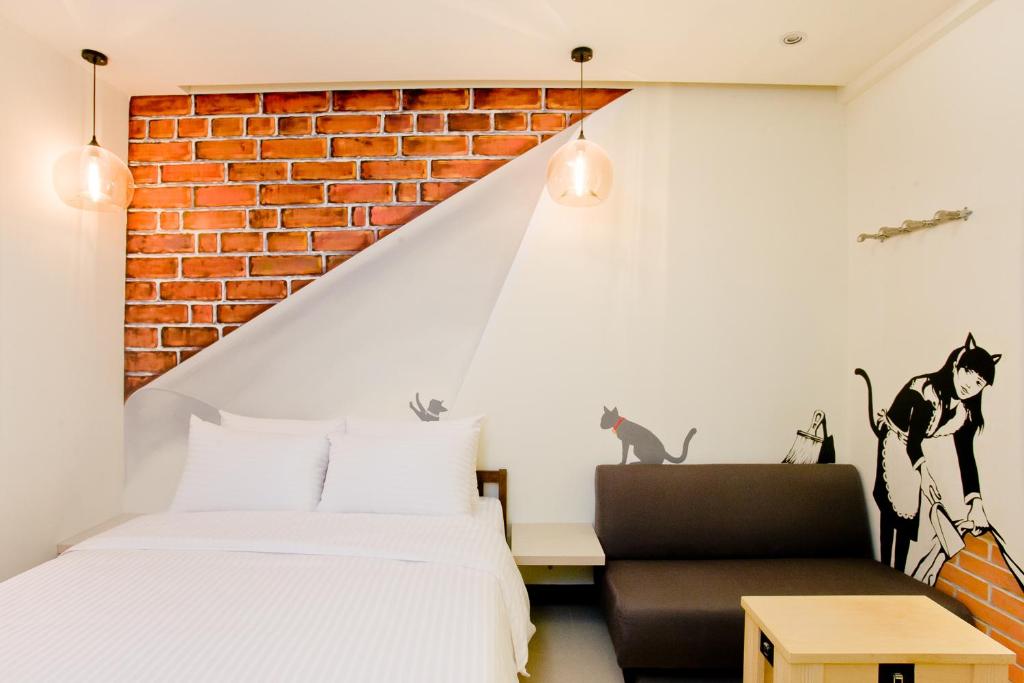 a bedroom with a bed and a brick wall at Dong Men Hotel in Taipei