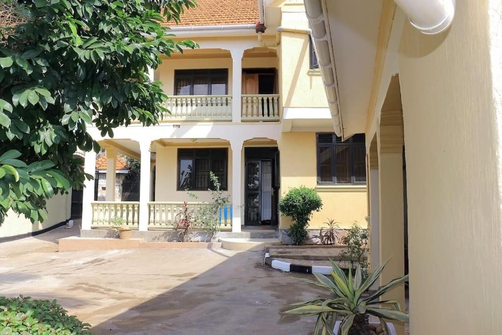 un edificio amarillo con un balcón en el lateral. en Prax suits, en Kampala