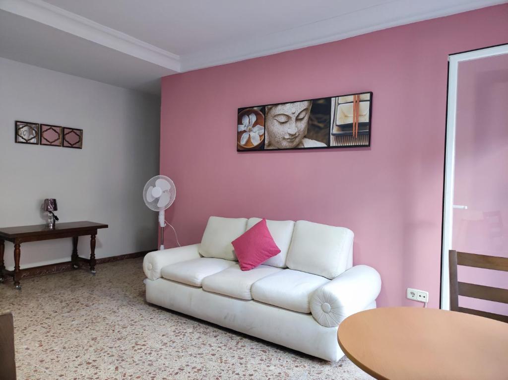uma sala de estar com um sofá branco e uma mesa em LUCERO APARTAMENTO em Madri