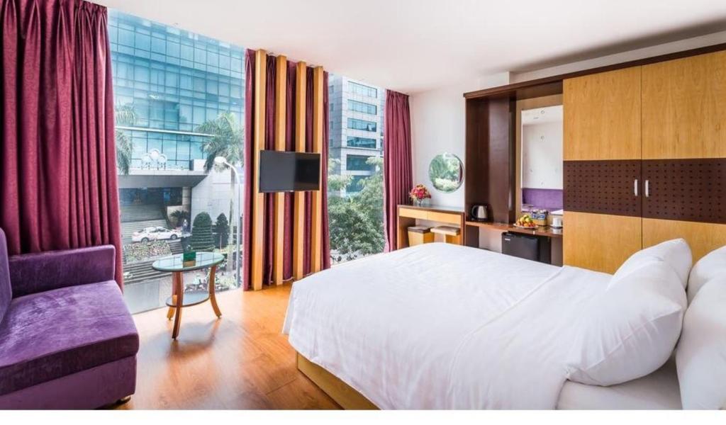 um quarto com uma cama branca e uma grande janela em OYO 1162 Tu Sakura Hotel em Hanói