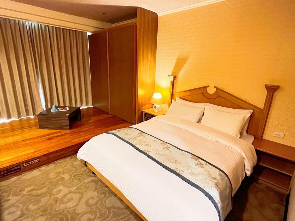 a bedroom with a large bed and a window at APVC Lukang Resort in Lugang