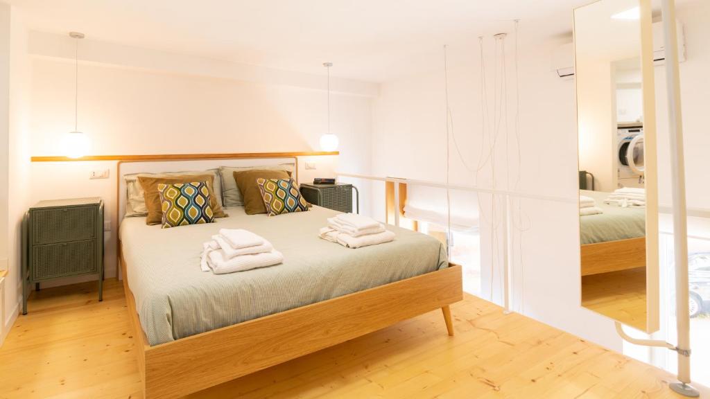 1 dormitorio con 1 cama con 2 toallas en Welcomely - Civico 65-40, en Nuoro