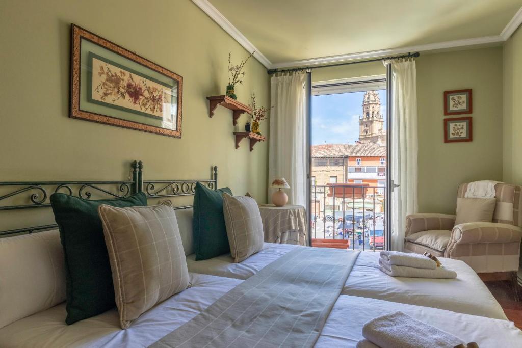 ein Schlafzimmer mit einem Bett und einem großen Fenster in der Unterkunft La casa del mercadillo, Haro in Haro