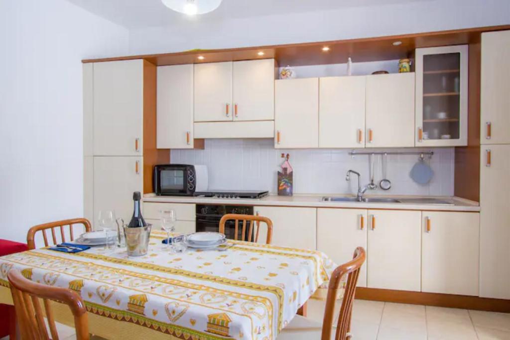 a kitchen with a table and a kitchen with white cabinets at Villa Lucetta in Otranto
