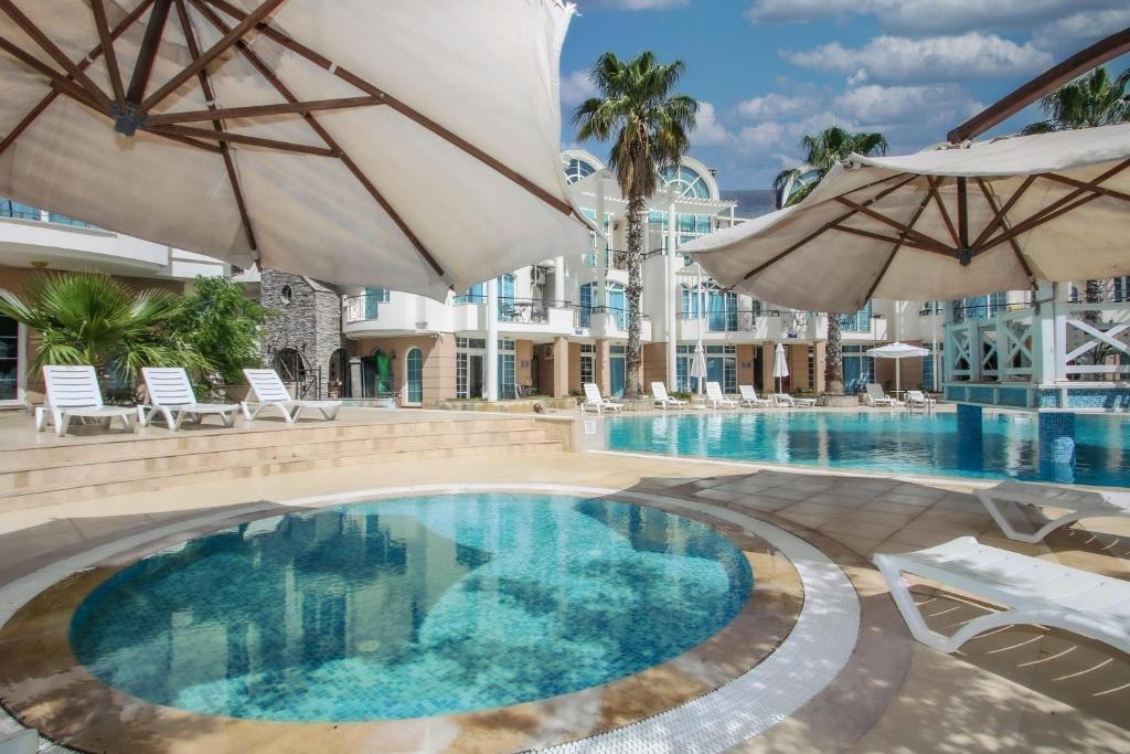 uma piscina com dois guarda-sóis e um resort em Seahorse Deluxe Hotel em Didim