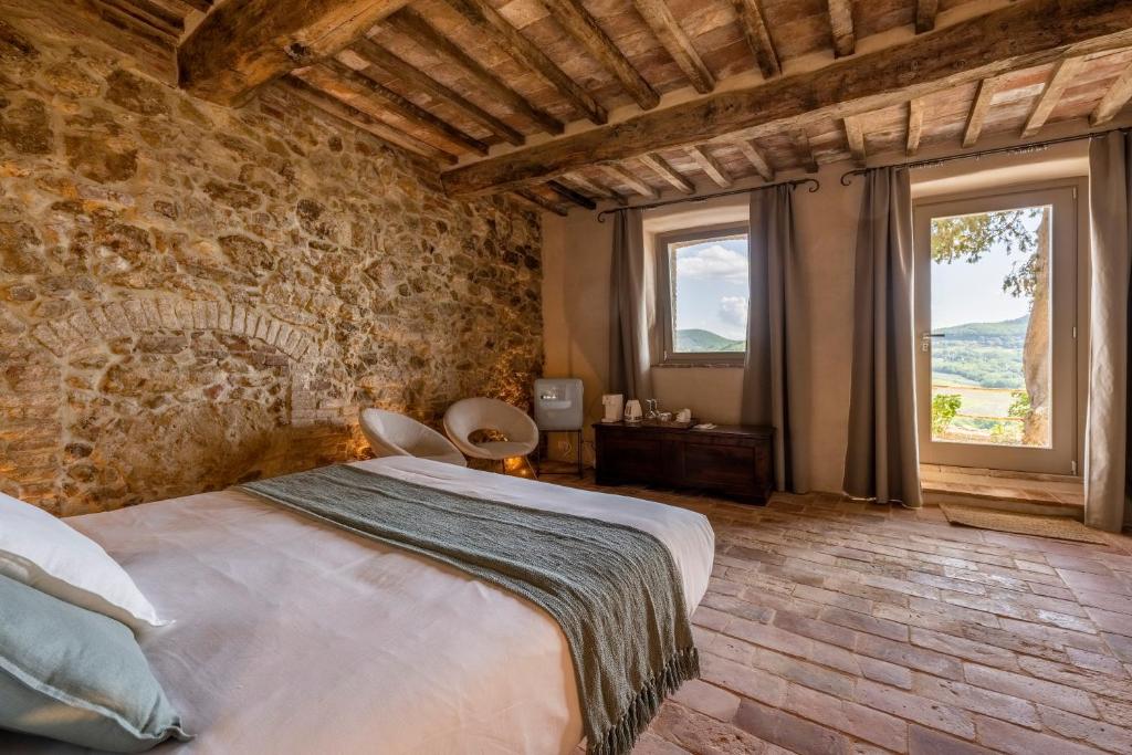 a bedroom with a large bed in a stone wall at Stelle di Monte in Montepulciano