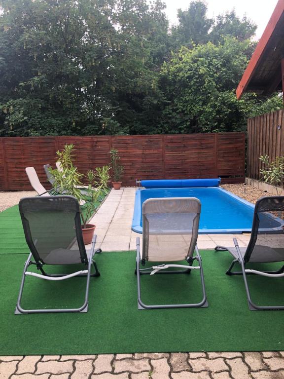 three chairs and a pool table in a backyard at Napház Apartman in Tiszafüred