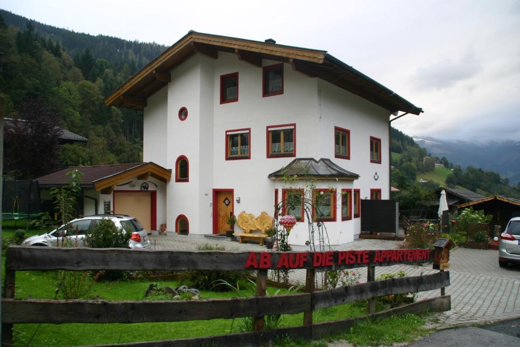 a white house with a sign in front of it at Appartement Schmittenblick in Zell am See