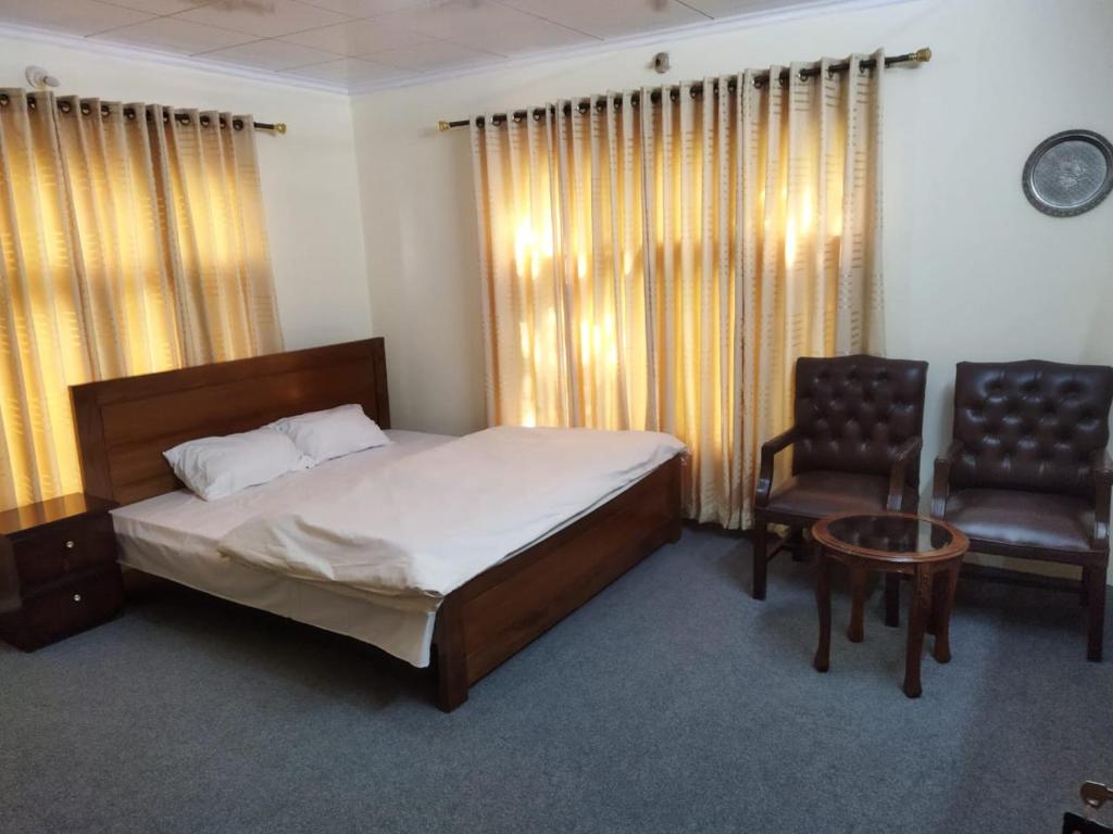 una camera con letto e sedia di Chinar Residency a Skardu