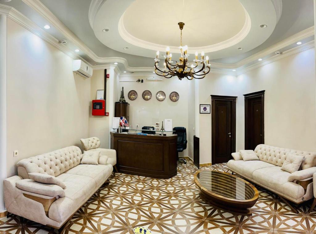 a living room with two couches and a chandelier at Eiffel Hotel in Batumi