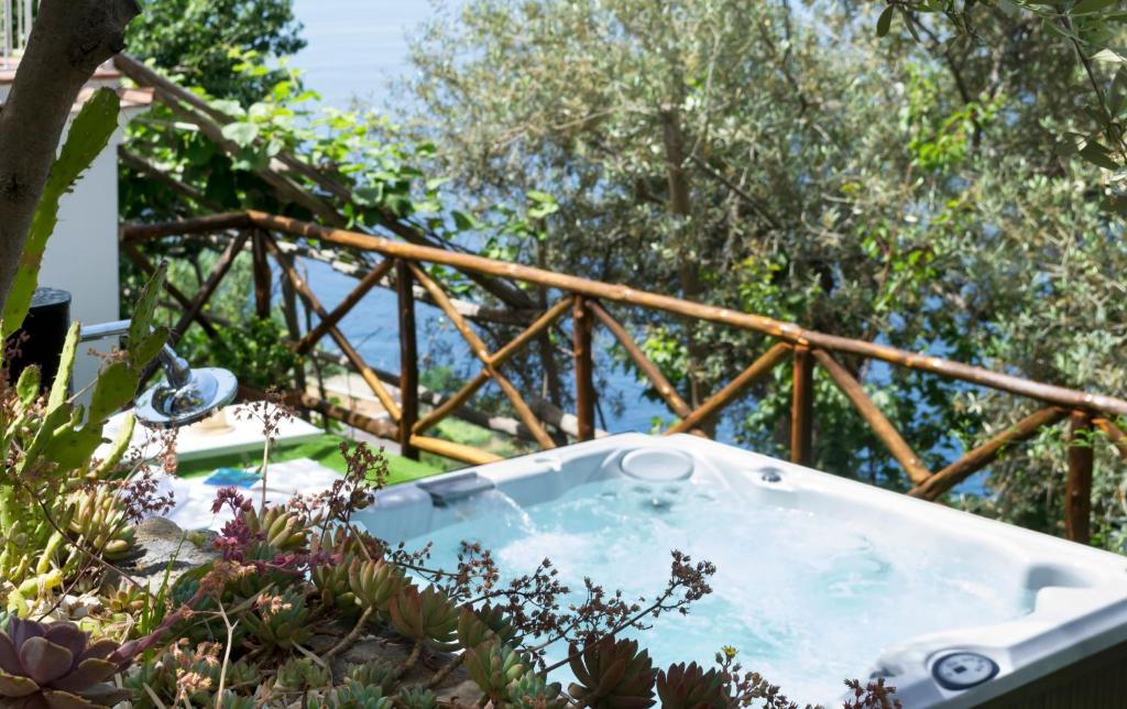 a jacuzzi tub on a balcony with a wooden railing at Residence Lì Galli in Praiano