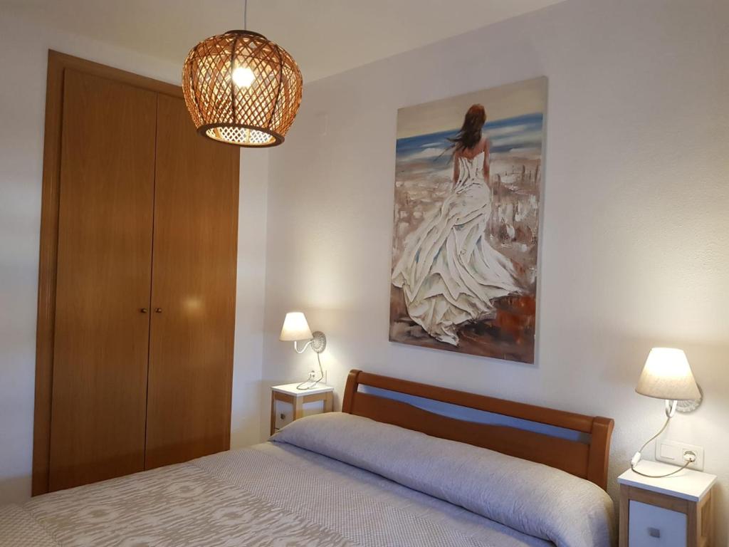 1 dormitorio con 1 cama y una pintura en la pared en Marina dor Frontal 1ª línea, en Oropesa del Mar