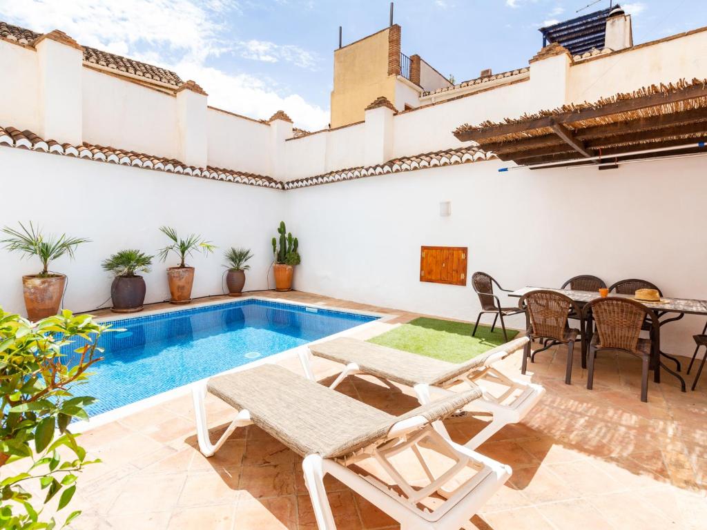 a villa with a swimming pool and a table and chairs at Casa del patio arabe in Albuñuelas