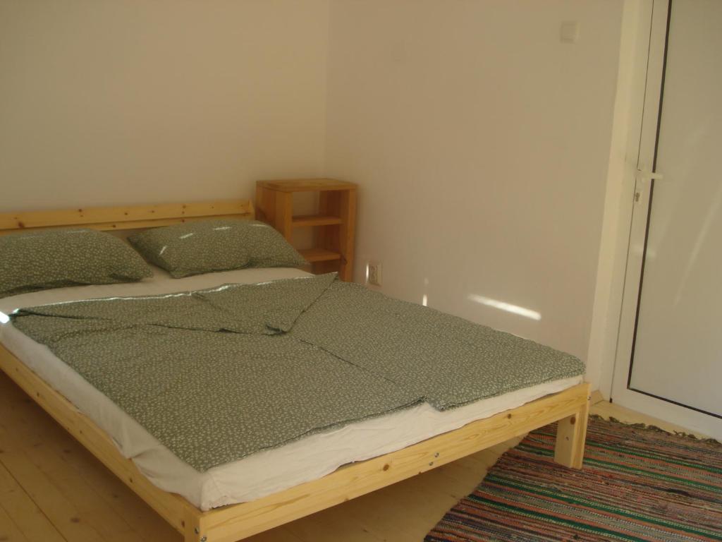 1 dormitorio con cama de madera en una habitación en Втори километър, en Ovcha Mogila