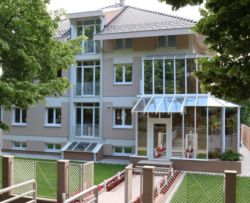 a house with a greenhouse in front of it at Grand Park rooms & apartments in Čačak