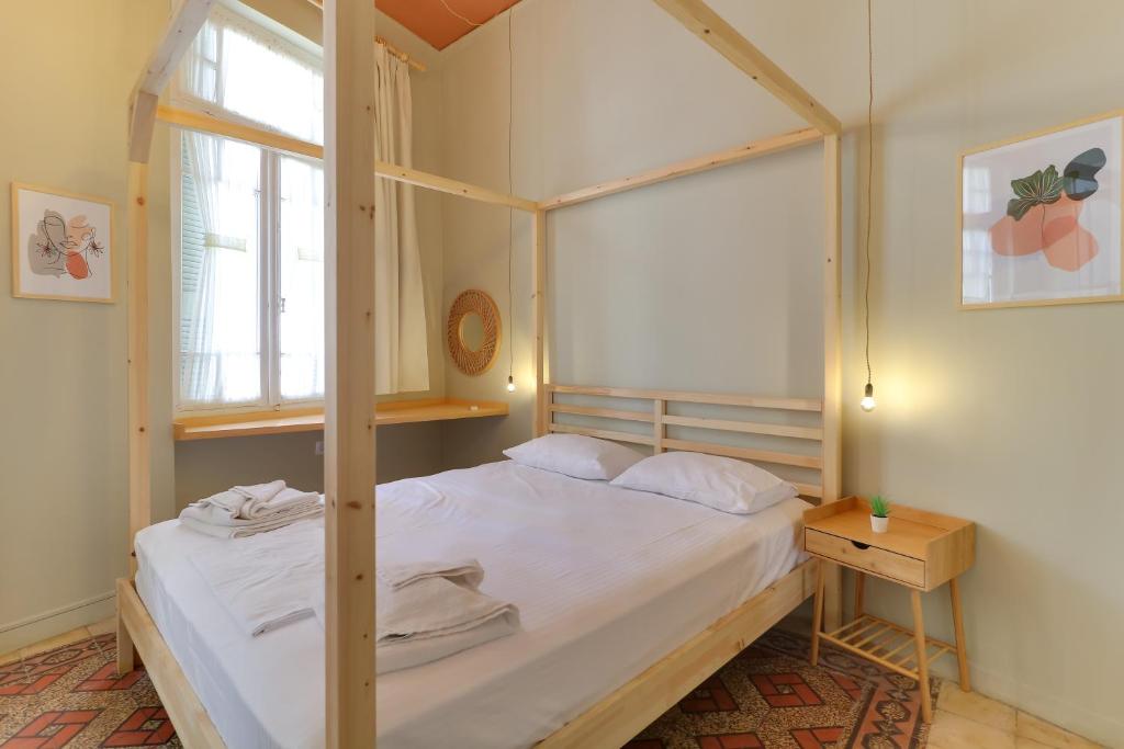 - une chambre avec un lit à baldaquin et une fenêtre dans l'établissement athensvintage, à Athènes