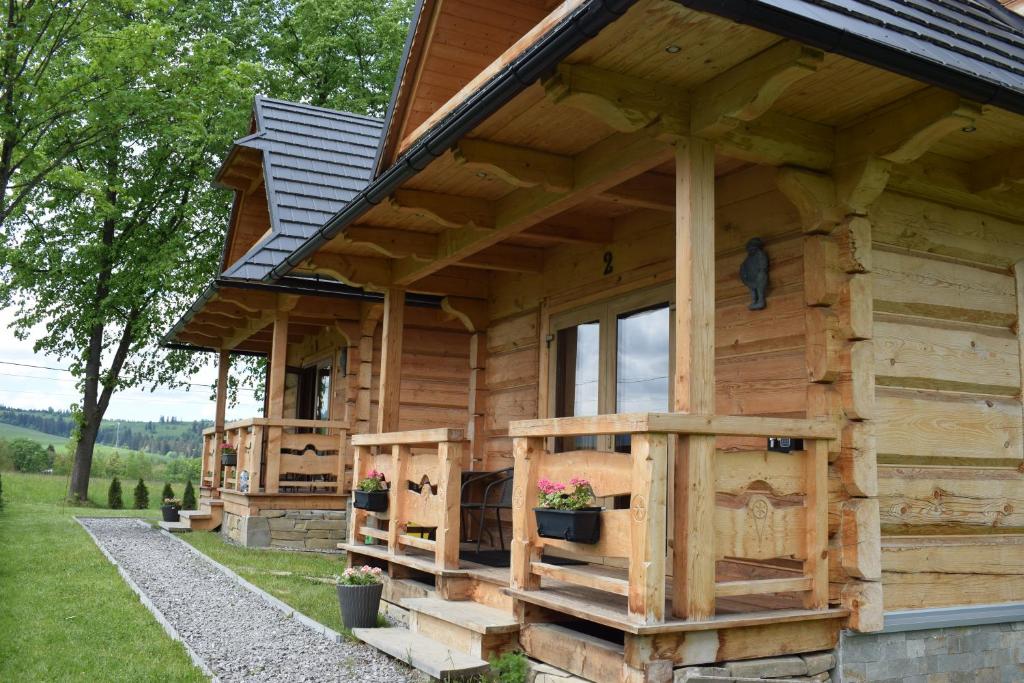 a wooden cabin with a gambrel roof at Osada Zagrody Dzianisz in Dzianisz