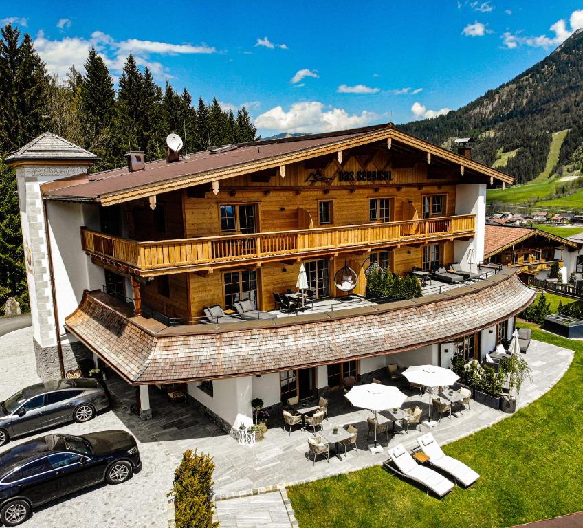 uma grande casa de madeira com um carro estacionado em frente em Hotel-Garni "Das Seebichl" em Achenkirch