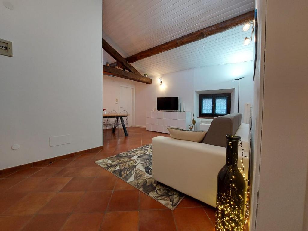 ein Wohnzimmer mit einem weißen Sofa und einem TV in der Unterkunft Bastione Apartment in Riva del Garda