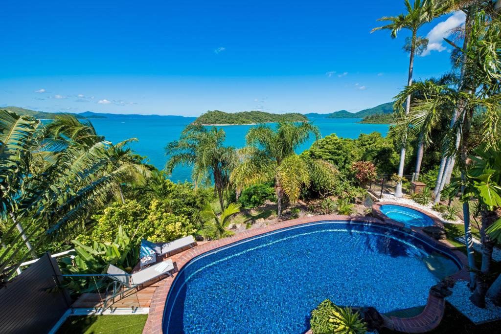 an aerial view of a swimming pool and the ocean at Coral Sea Pearl in Shute Harbour