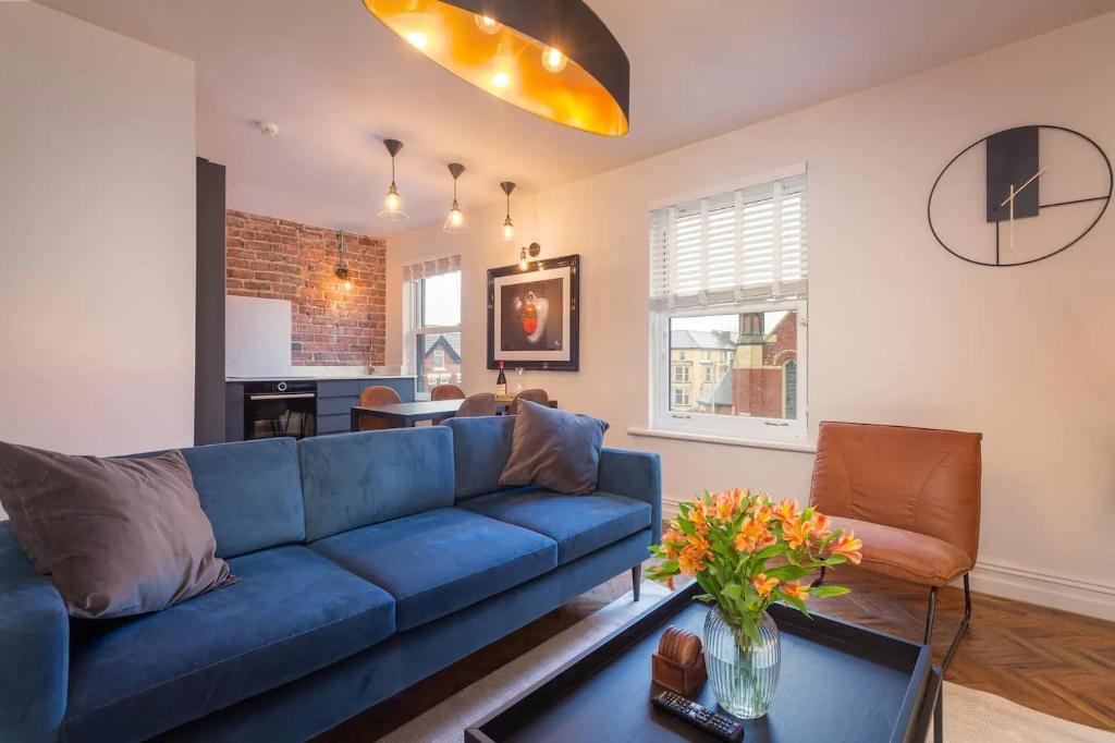 a living room with a blue couch and a table at Capri Stays - Apartment Two - Two Bed Apartment in Blackpool