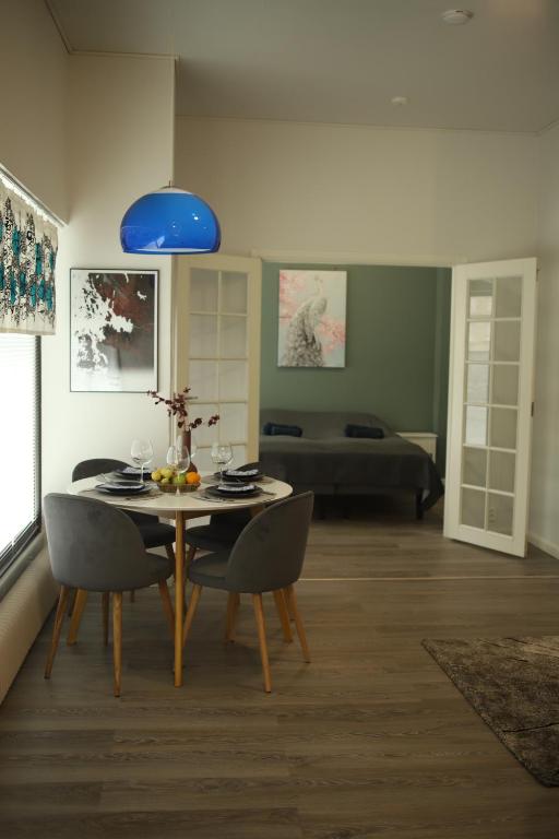 uma sala de jantar com uma mesa com cadeiras e uma luz azul em City Center 2-rooms apartment em Vaasa