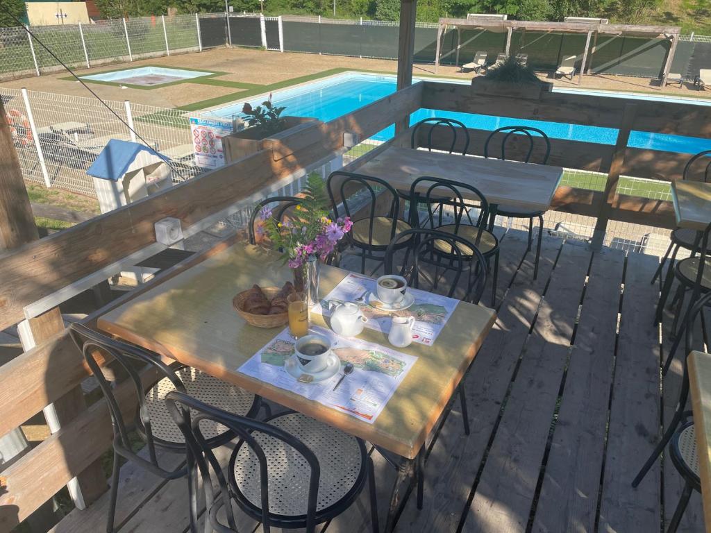 - une table et des chaises sur une terrasse à côté de la piscine dans l'établissement Camping La Bernede, à Rennes-les-Bains