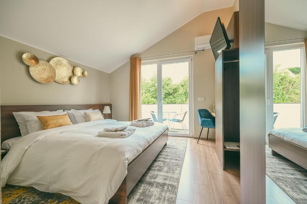 een slaapkamer met een groot bed en een balkon bij Hôtel Casa 49 in Remich