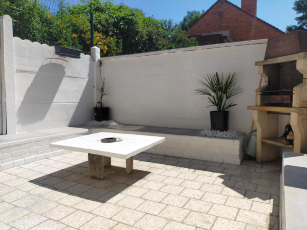 białe patio z ławką i stołem w obiekcie Maison de 3 chambres avec jardin clos et wifi a Lens w mieście Lens