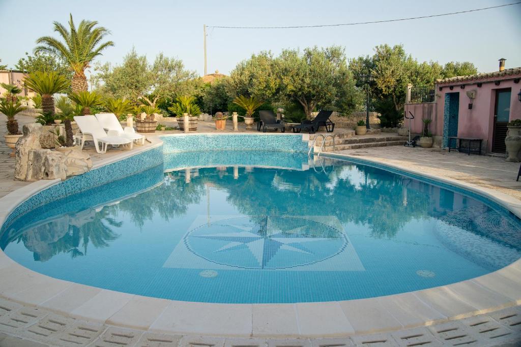 a swimming pool with blue water in a yard at Villa Vi in Ragusa