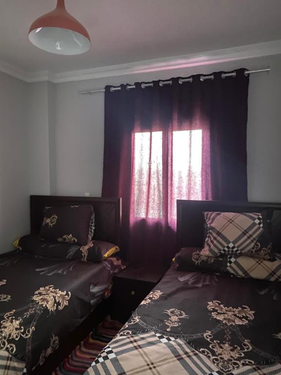 a bedroom with two beds and a window at شاليه قرية ريفيرا 1 in Ras Sedr