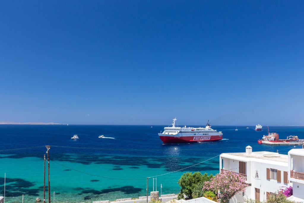 a large boat in the water next to the ocean at NAMASTE Boutique Apartments Mykonos in Tourlos